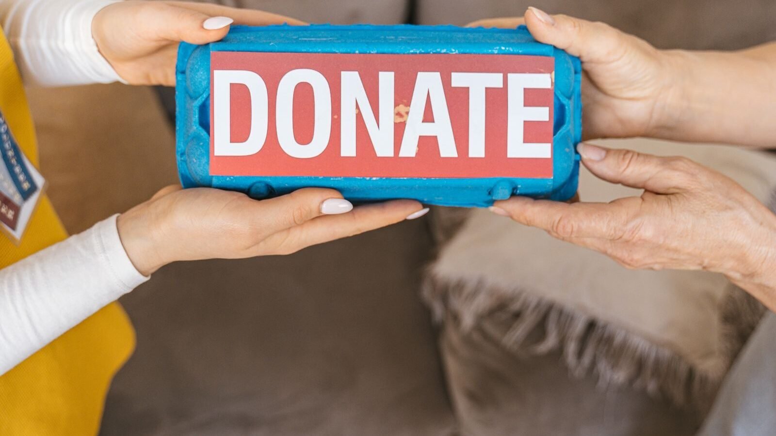 Hands exchanging a donation sign, representing charitable grant funding
