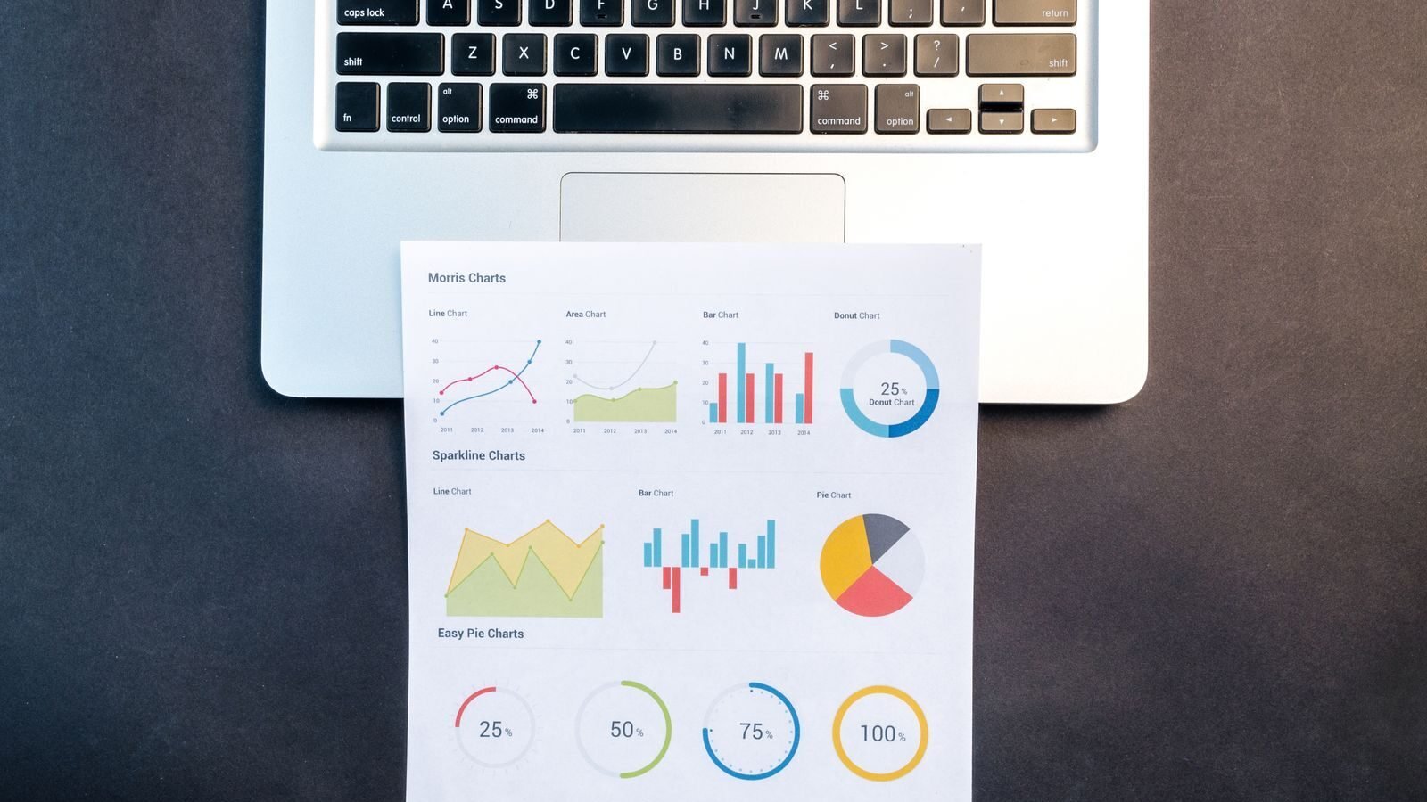 Charts and printed reports next to a laptop for analyzing nonprofit data