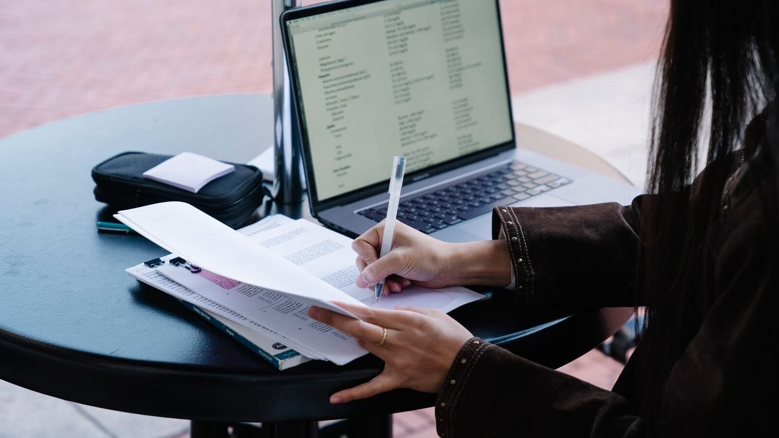 Person researching nonprofit records on a laptop with documents
