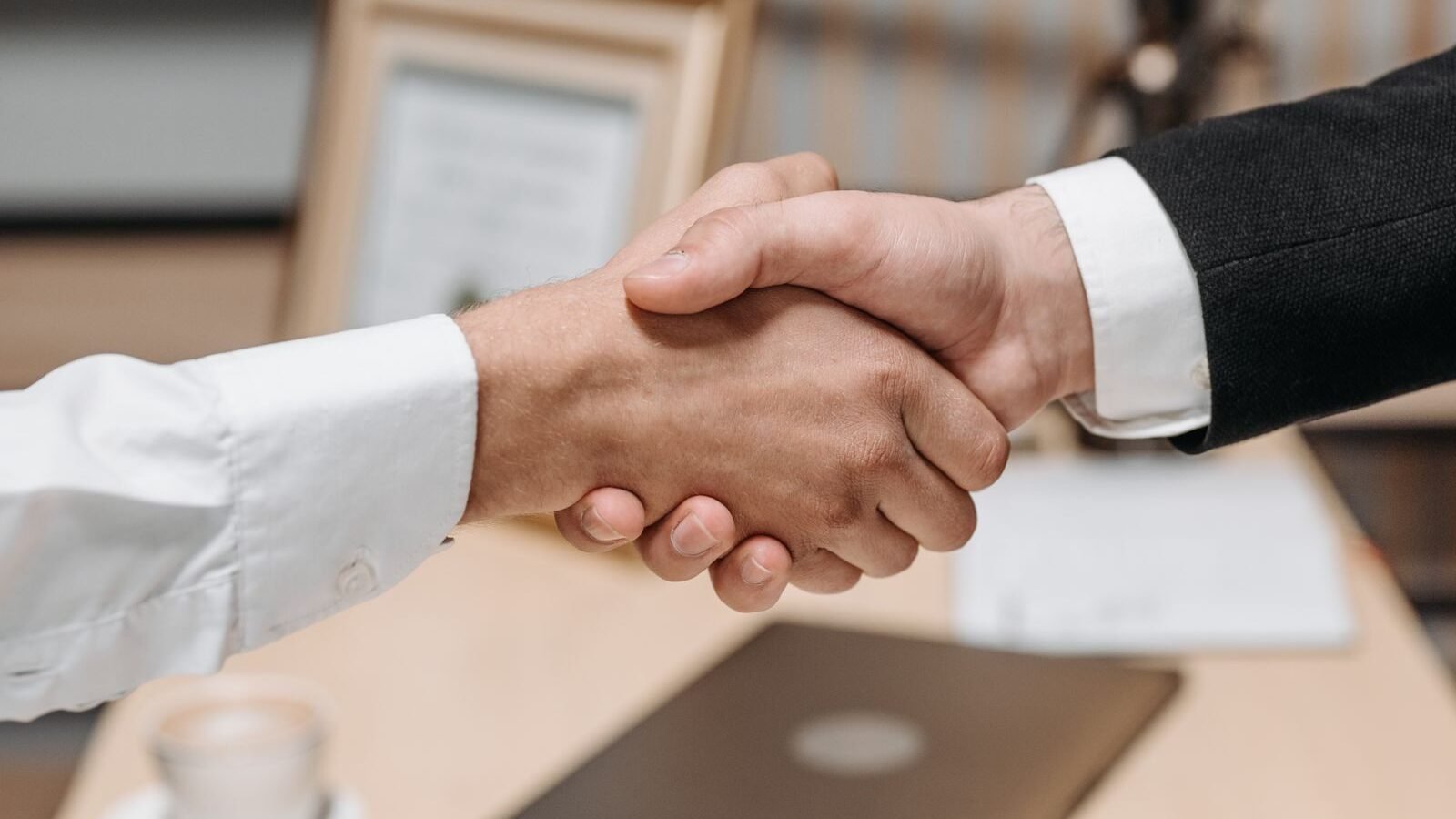 Vendor and nonprofit staff member shaking hands after a meeting